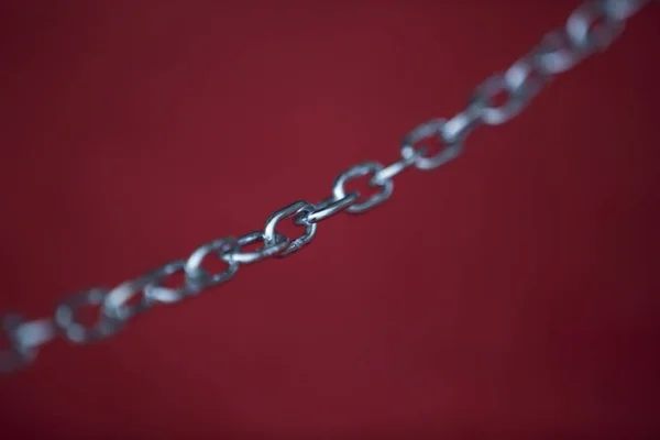 Steel chain on red background — Stock Photo, Image