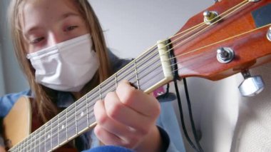 Karantina zamanında evde gitar çalmak. Genç kız evde yalnız kalıyor. Ayrıntılı çekim