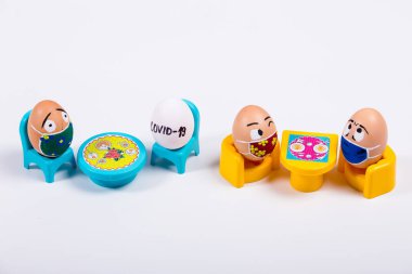 Tıbbi maske takan, karalama yüzlü çeşitli tavuk yumurtaları. Corona virüs salgını sırasındaki Paskalya 'nın kavramsal görüntüsü. Evde karantina.