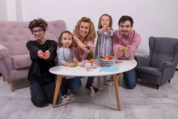 Anne, baba, oğul ve kızlar yumurta boyuyor. Mutlu aile Paskalya için hazırlanıyor. Evde karantina.