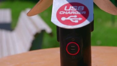 Parktaki bir USB sokak şarj aletinin aşağıdan yukarıya hareket eden yakın çekim çerçevesi