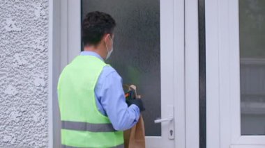 Kurye eve mal getiriyor. Karantina telefonundaki kolejlerin teslimatı.