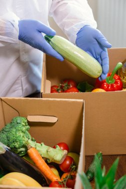 Paket servis ve kapı teslimatı. Koruyucu takım elbiseli, eldivenli ve maskeli bir toplayıcı sipariş et. Coronavirus hastalığı (COVID-19) salgını.
