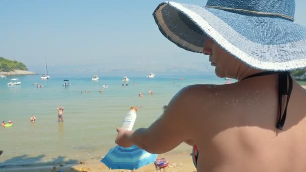 太陽のクリームを適用するビーチや砂浜のビーチで彼女の体に日焼けオイルのブラチ島 クロアチア 2017 エディトリアル使用のみ — ストック動画