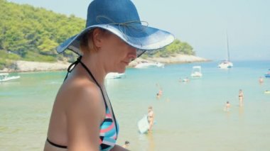 Sahilde genç kadınla. Belgili tanımlık smartphone üzerinde cevap. Güzel güneşli yaz günü. Yeryüzündeki cennet. Lovrecina beach Island Brac, Hırvatistan.