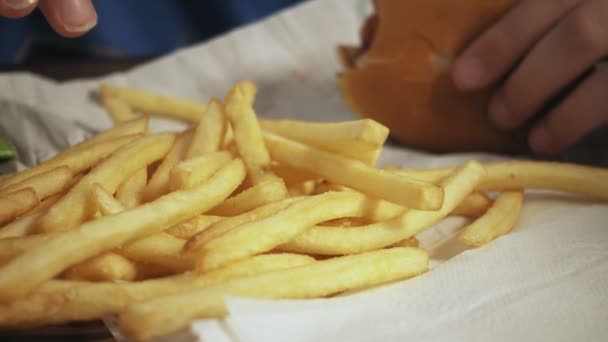 Ung Pojke Äta Hamburgare Och Pommes Frites Snabbmatsrestaurang — Stockvideo