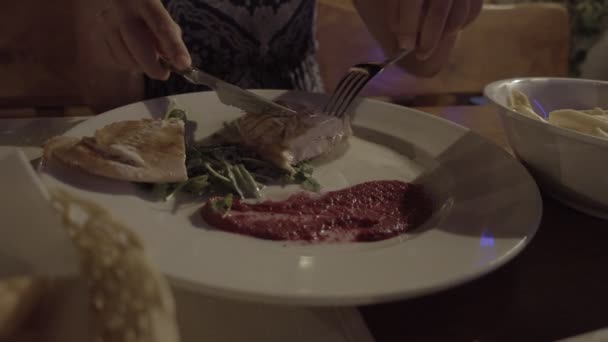 在餐馆的露台吃的年轻女人 用食物把盘子合上 晚上晚上拍摄 — 图库视频影像