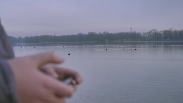 Młody Chłopak Stoi Nad Brzegiem Jeziora Przy Użyciu Smartfona Zimowego — Wideo stockowe