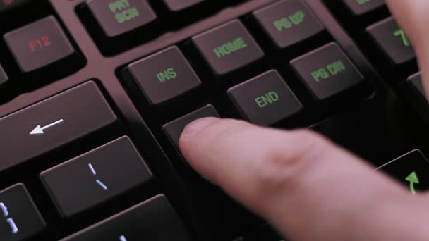 男を押すとモダンな照らされたコンピューターのキーボード上のキーを削除します — ストック動画