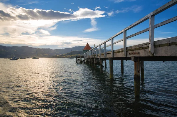 Akaroa Bay, Christchurch, Yeni Zelanda yakınındaki ahşap iskele gün batımı görünümü