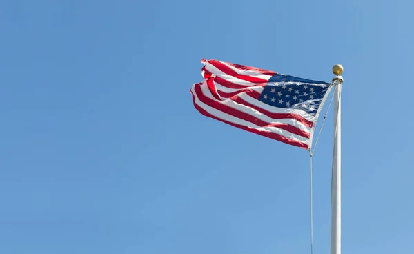 Amerika Birleşik Devletleri bayrağı sola açık mavi gökyüzü arka plan üzerinde akar