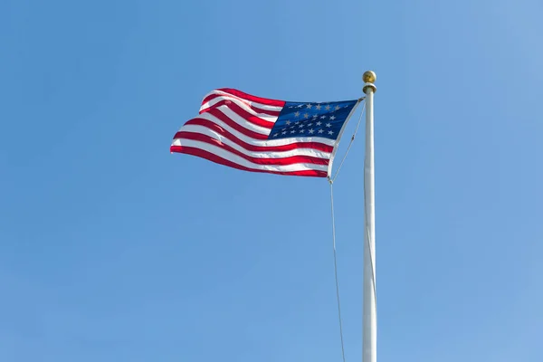 Sola açık mavi gökyüzü arka plan üzerinde Amerikan bayrağı