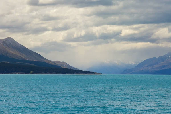 Ağır bulutlar ve göl Pukaki dağlardaki ön planda, Yeni Zelanda, Güney Adası, Canterbury