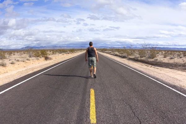 Walking alone on a lone desert highway — Stock Photo, Image