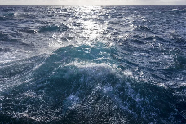 Грубый бурный океан под отражающим солнцем — стоковое фото