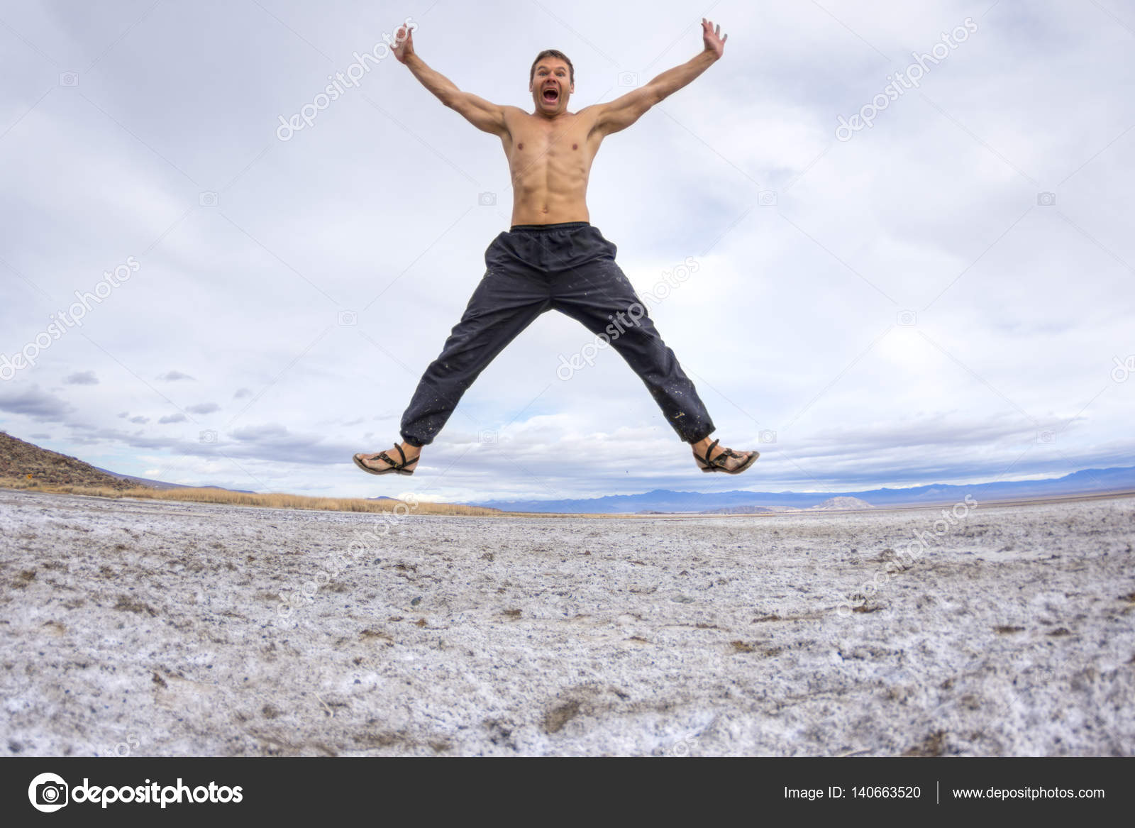 et avec Torse sale homme de dans lac Noir pantalon jambes asséché de sauts les désert en de et les nu le tendus lit race blanche avec sandales l'air bras D92IWEH