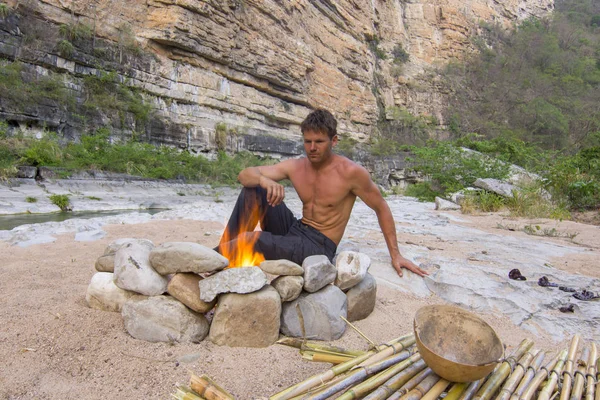 Uomo seduto al campeggio primitivo con il fuoco — Foto Stock