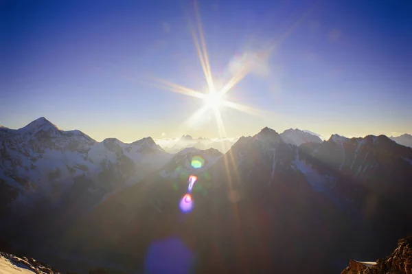 Belo pôr do sol com raios de sol nas montanhas — Fotografia de Stock