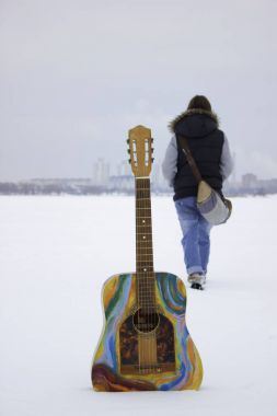 Kız gidiyor ile derin karda renkli gitar ayakta
