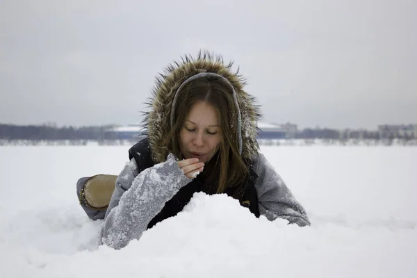 雪の上を敷設の美しい若い女性 — ストック写真