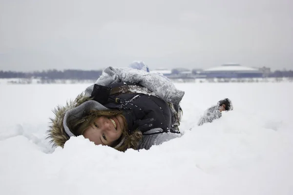 Linda chica riendo tendida en la nieve —  Fotos de Stock