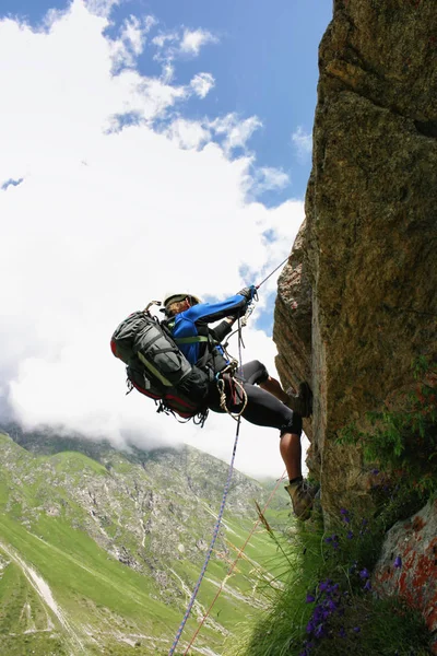 Альпинист взбирается на скалу по веревке . — стоковое фото