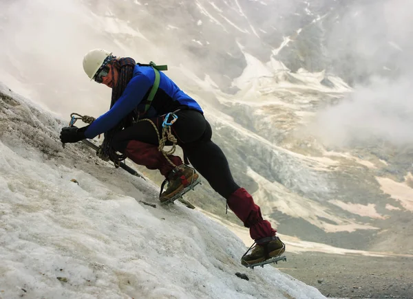 The climber climbs the glacier. Stock Photo