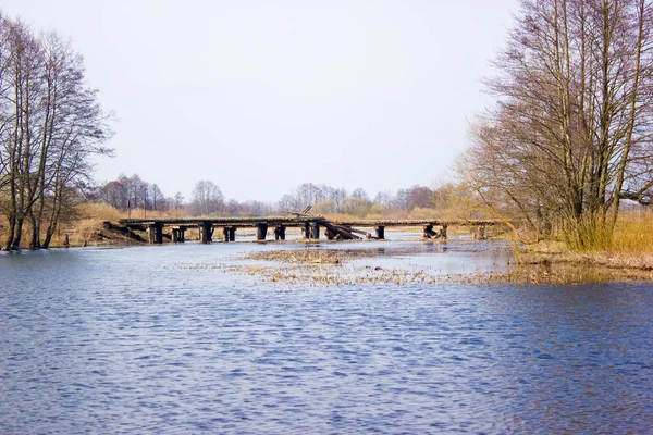 Old wooden bridge over the river. — Stock Photo, Image