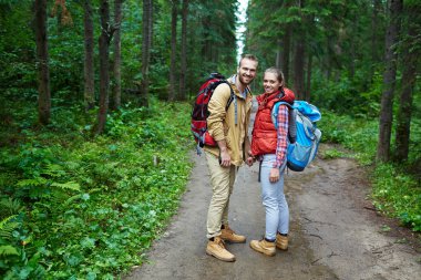 Orman yolu üzerinde duran genç turist