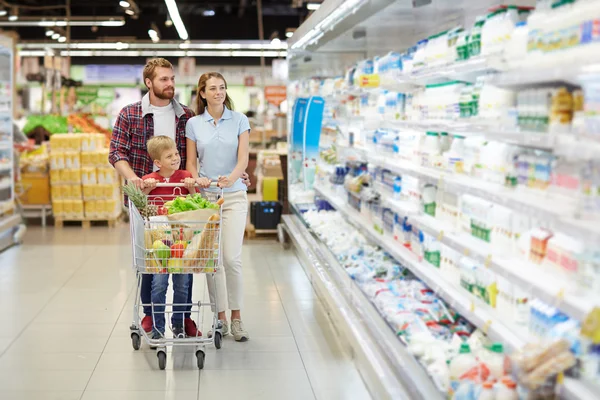 Пара и их сын покупают продукты в супермаркете — стоковое фото