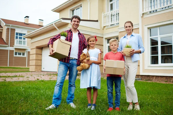 Yeni house yakınındaki kutuları ile aile — Stok fotoğraf