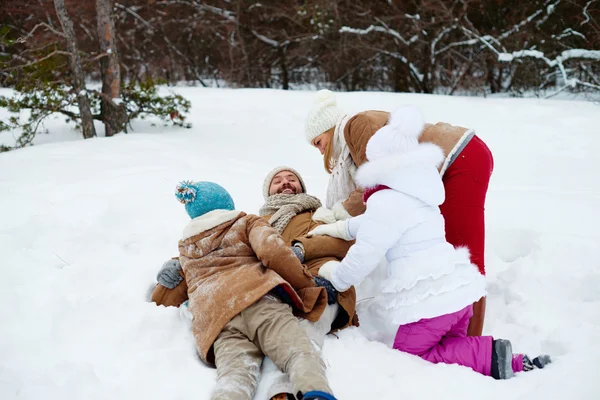 雪の吹きだまりで楽しく遊び心のある家族 — ストック写真