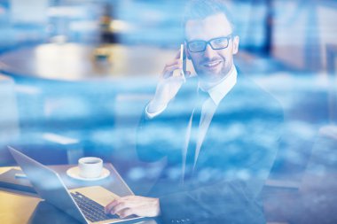 İş adamı cep telefonuyla konuşuyor.