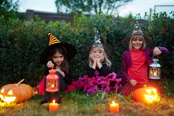 Little witches sitting on grass — Stock fotografie