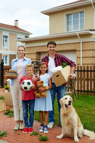 Famille debout dans la cour par une nouvelle maison — Photo