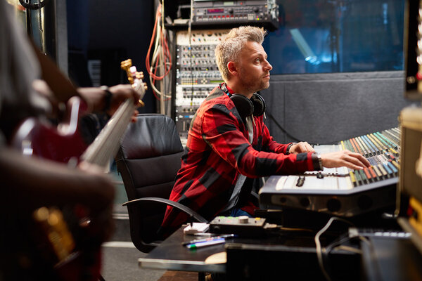 Male operator recording music in studio