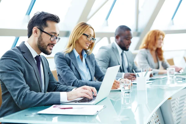 Businessman typing on laptop at conference — Stock Photo, Image