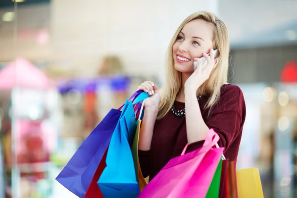 Mujer con bolsas de compras hablando por teléfono celular —  Fotos de Stock