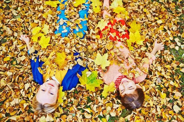 Lächelnde Kinder in goldenen Blättern — Stockfoto