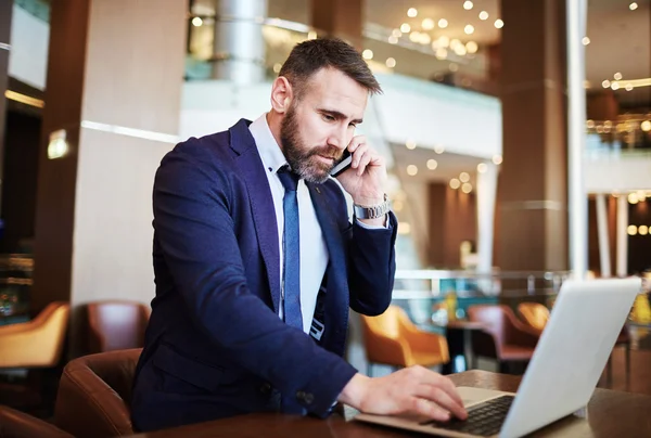 Businessman working in hotel calling to his partner — Stock Photo, Image