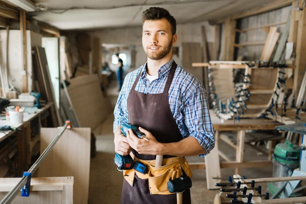 Плотник-мужчина с дрелью в мастерской — стоковое фото