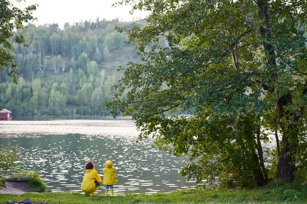 Parent and kid enjoying time by lake — Stock Photo, Image