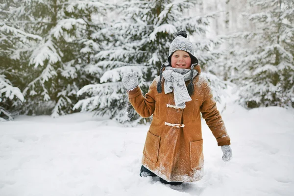 Щасливий хлопчик грає в сніжки в парку — стокове фото