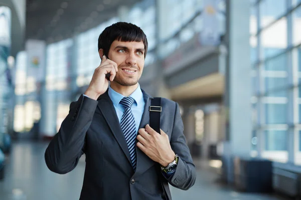 Hombre de negocios sonriente hablando por teléfono celular — Foto de Stock