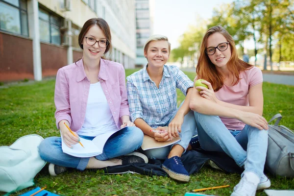 Grupo de chicas amistosas sentadas en el campus — Foto de Stock
