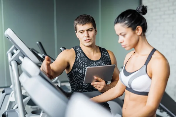 Young trainer with active girl in gym — Stock Photo, Image