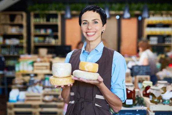 Seller of dairy products holding cheese — Stock Photo, Image