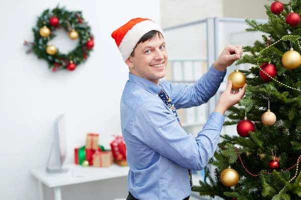 Zakenman opknoping bellen op de kerstboom — Stockfoto