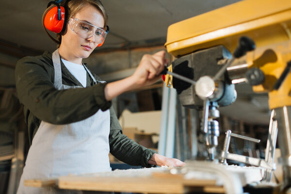 Woodworker processing timber on special machine 