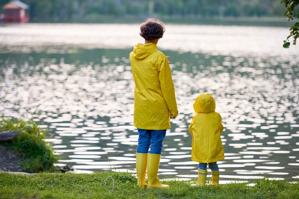 Mujer y su pequeño hijo de pie junto al río — Foto de Stock